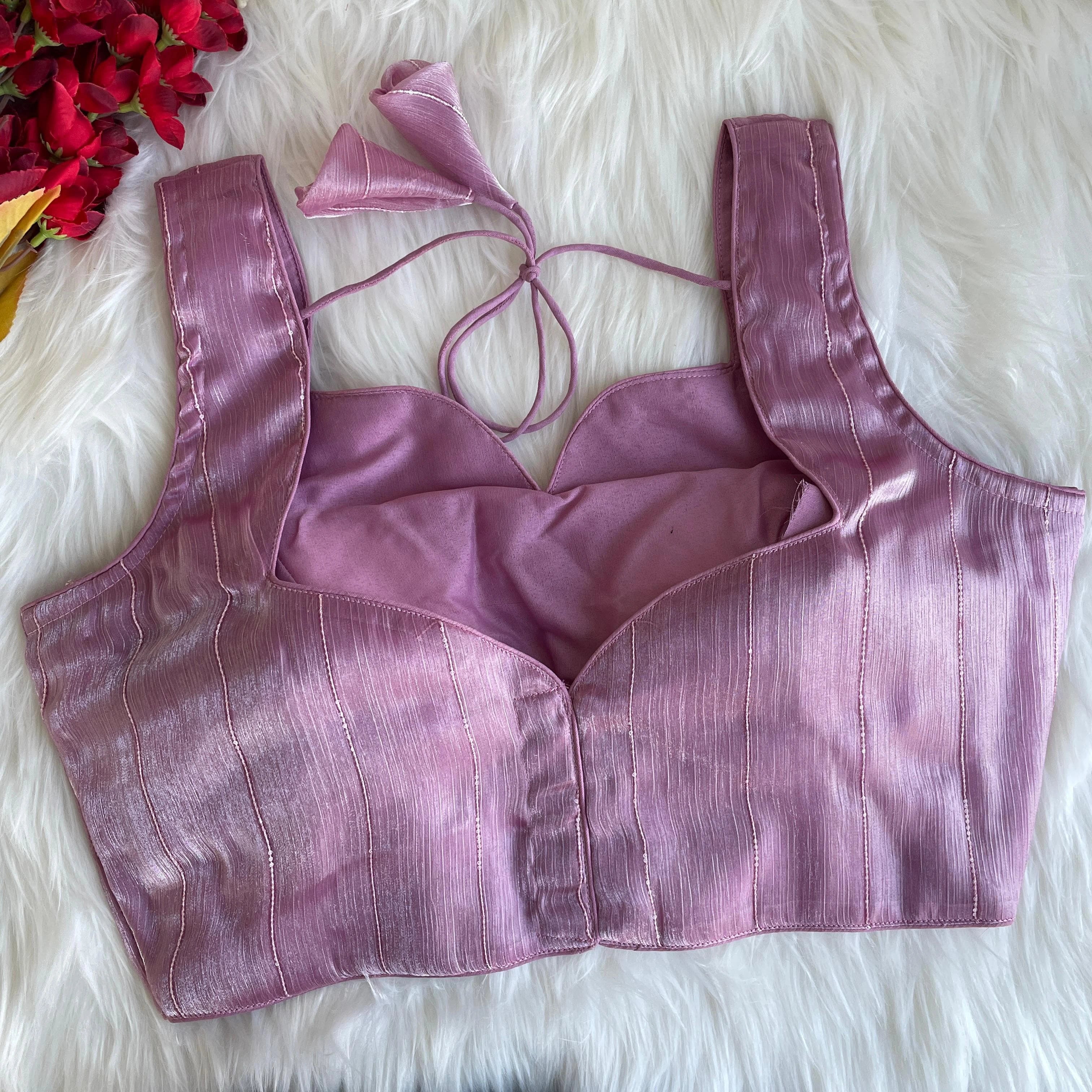 Purple bralette on a white fur surface with red flowers in the corner